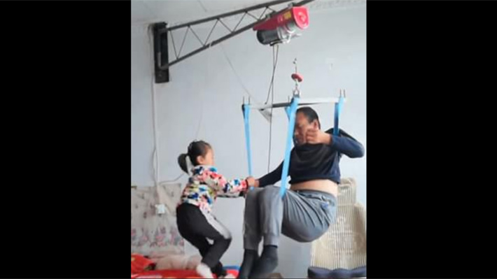 La mamá los abandonó: Niña de seis años conmueve a China al cuidar a su padre con discapacidad física