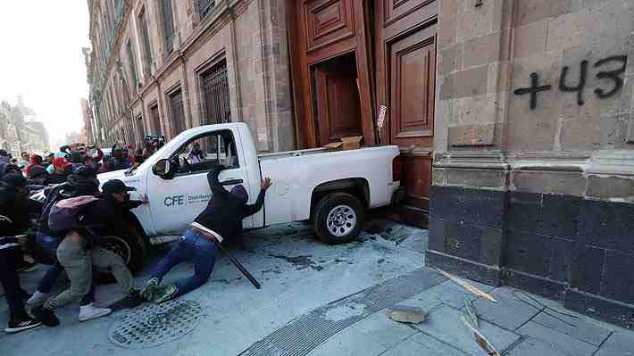 Caos en México: Manifestantes de Ayotzinapa derriban puerta del palacio presidencial durante conferencia de AMLO