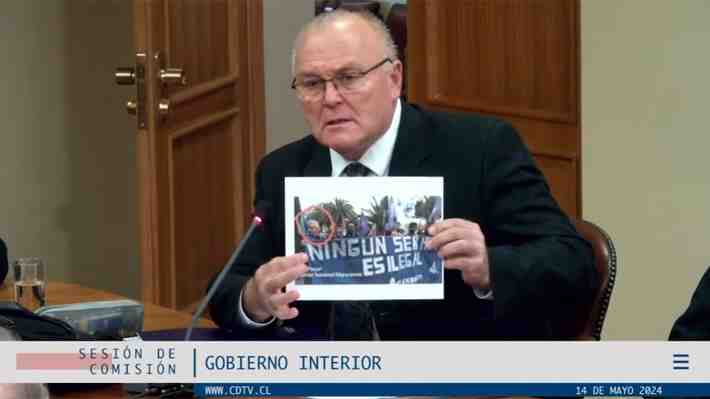 Foto con lienzo que dice "ningún ser humano es ilegal" complica a director de migraciones en el Congreso
